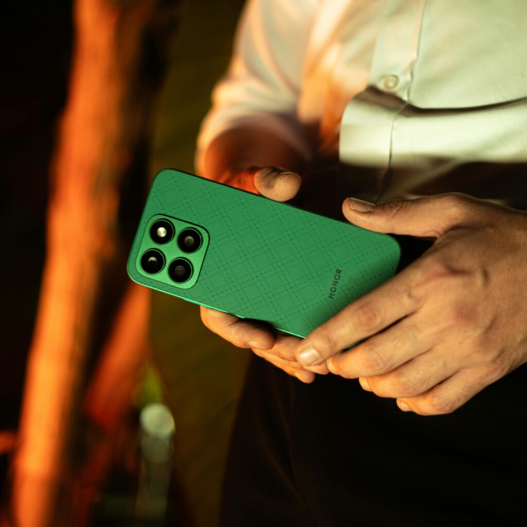 A man holding a green smartphone with a focus on modern design and technology.